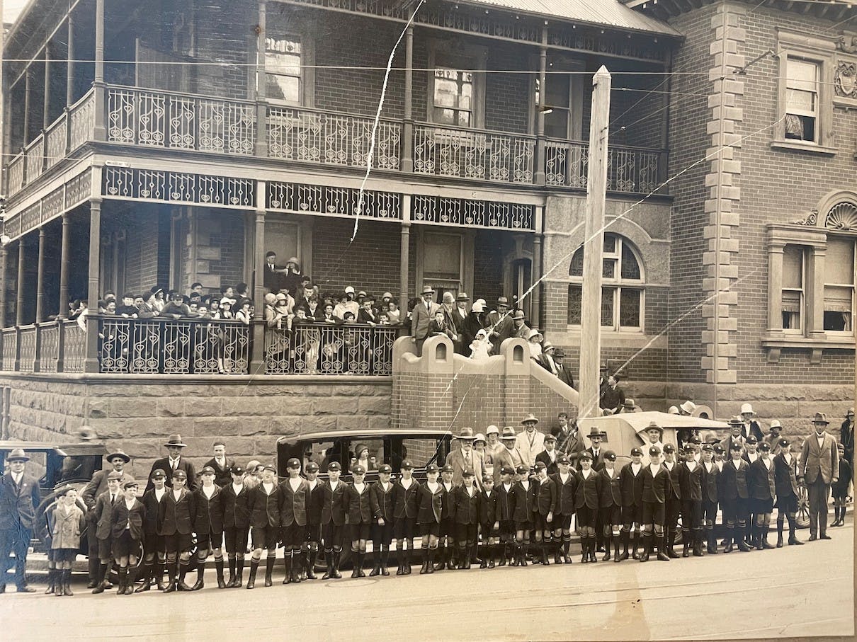 Vintage image of a building with people standing on the balcony and outside
